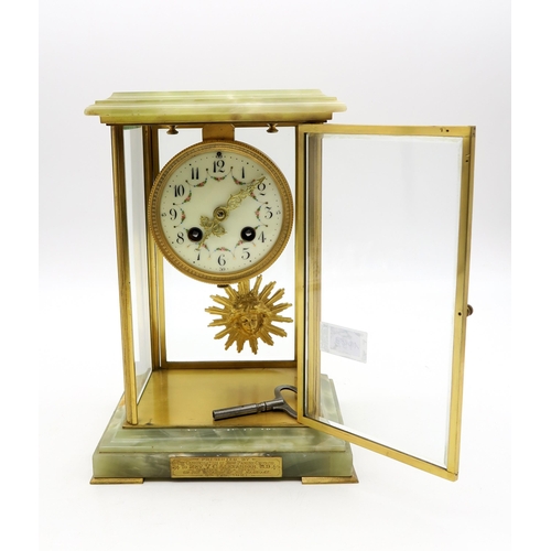 192 - A French onyx clock with sun face pendulum, the enamelled dial with floral swag decoration