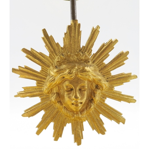 192 - A French onyx clock with sun face pendulum, the enamelled dial with floral swag decoration