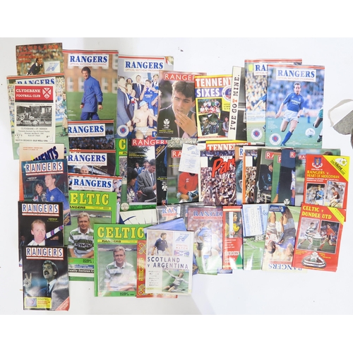 570 - A large collection of 1980s-era Rangers and Celtic F.C. football programmes and related ephemera, in... 