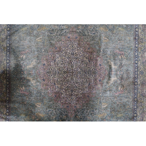 70 - A green ground Axminster style rug with beige central medallion on ground decorated trees and styliz... 