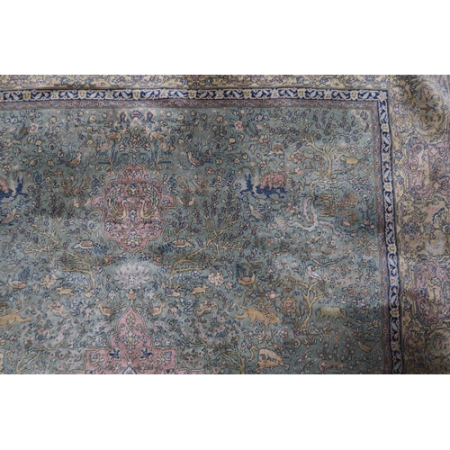 70 - A green ground Axminster style rug with beige central medallion on ground decorated trees and styliz... 