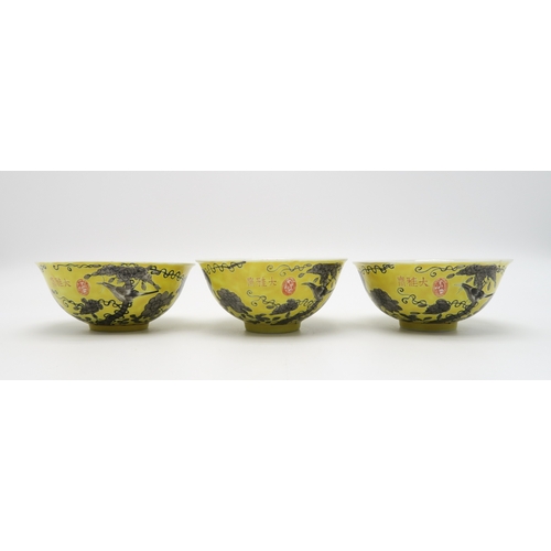 2367 - THREE CHINESE YELLOW GROUND BOWLSPainted with birds amongst scattered flowers and tendrils, gilt sea... 