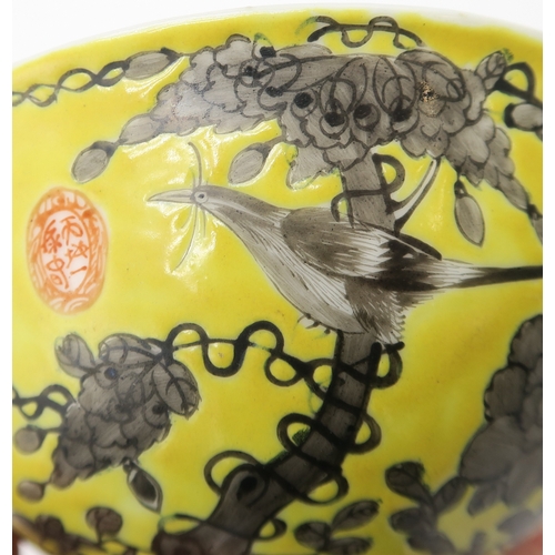 2367 - THREE CHINESE YELLOW GROUND BOWLSPainted with birds amongst scattered flowers and tendrils, gilt sea... 