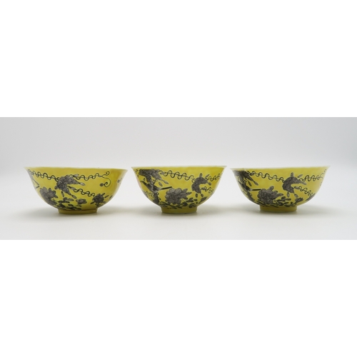 2367 - THREE CHINESE YELLOW GROUND BOWLSPainted with birds amongst scattered flowers and tendrils, gilt sea... 