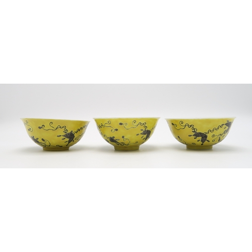 2367 - THREE CHINESE YELLOW GROUND BOWLSPainted with birds amongst scattered flowers and tendrils, gilt sea... 