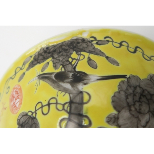 2367 - THREE CHINESE YELLOW GROUND BOWLSPainted with birds amongst scattered flowers and tendrils, gilt sea... 