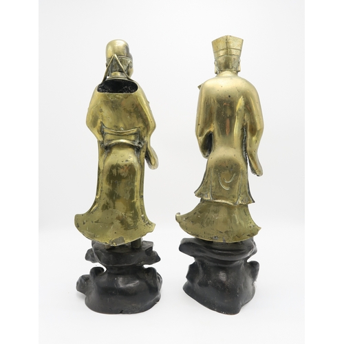 2374 - A PAIR OF CHINESE BRASS OFFICIALSEach standing and holding an object on a high rocky mound base,58cm... 