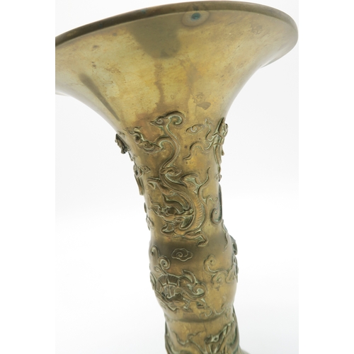 2375 - A CHINESE BRASS GU VESSEL Cast with sinuous creatures, on a wooden base, 26cm high, and two other ve... 