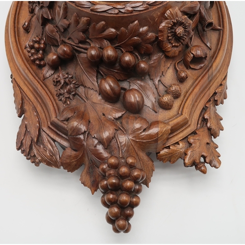 2216 - A 19TH CENTURY BLACK FOREST WALL CLOCKcarved profusely with fruits, flowers and foliage, the gilded ... 