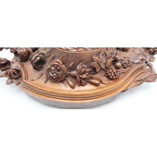 2216 - A 19TH CENTURY BLACK FOREST WALL CLOCKcarved profusely with fruits, flowers and foliage, the gilded ... 