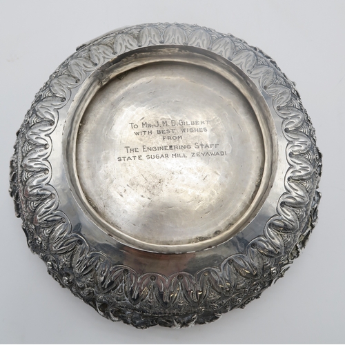 2363 - A BURMESE WHITE METAL PRESENTATION BOWLDecorated with oxen pulling carts and a boat divided by scrol... 