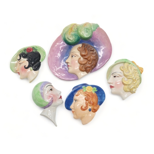 2186 - A COLLECTION OF ART DECO POTTERY WALL MASKSeach modelled as a woman's head, many by C Ltd including ... 