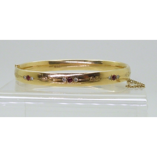 2750 - RUBY AND DIAMOND BANGLEmounted in heavy gauge solid 9ct gold, grain set with six diamonds with an es... 