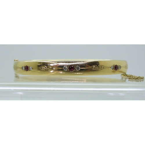 2750 - RUBY AND DIAMOND BANGLEmounted in heavy gauge solid 9ct gold, grain set with six diamonds with an es... 