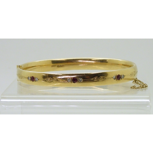 2750 - RUBY AND DIAMOND BANGLEmounted in heavy gauge solid 9ct gold, grain set with six diamonds with an es... 