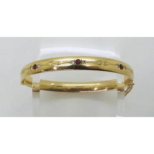 2750 - RUBY AND DIAMOND BANGLEmounted in heavy gauge solid 9ct gold, grain set with six diamonds with an es... 