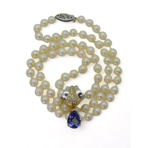 2754 - A TANZANITE AND DIAMOND PEARL CLIPmade in 18ct yellow and white gold, set with a pear-shaped tanzani... 