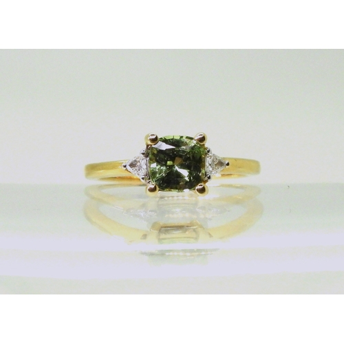 2757 - AN APATITE AND DIAMOND RINGset with a cushion cut pale green apatite, approx 6mm x 6mm, with two tri... 