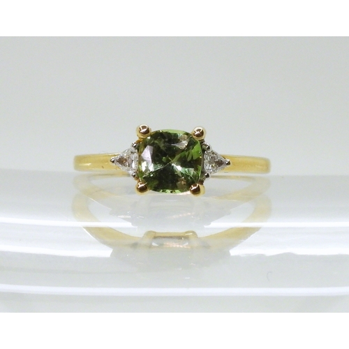 2757 - AN APATITE AND DIAMOND RINGset with a cushion cut pale green apatite, approx 6mm x 6mm, with two tri... 