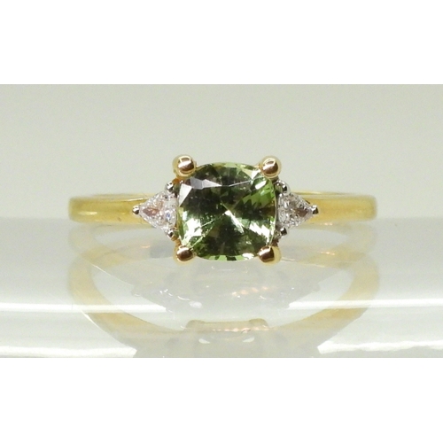 2757 - AN APATITE AND DIAMOND RINGset with a cushion cut pale green apatite, approx 6mm x 6mm, with two tri... 