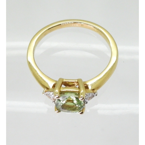 2757 - AN APATITE AND DIAMOND RINGset with a cushion cut pale green apatite, approx 6mm x 6mm, with two tri... 