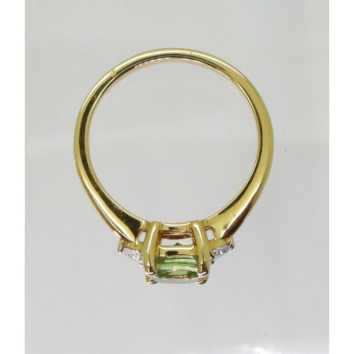 2757 - AN APATITE AND DIAMOND RINGset with a cushion cut pale green apatite, approx 6mm x 6mm, with two tri... 