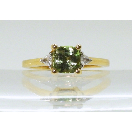 2757 - AN APATITE AND DIAMOND RINGset with a cushion cut pale green apatite, approx 6mm x 6mm, with two tri... 