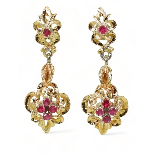 2763 - A PAIR OF CANADIAN RUBY EARRINGSthe pretty scroll mount is made in yellow and white metal and set wi... 