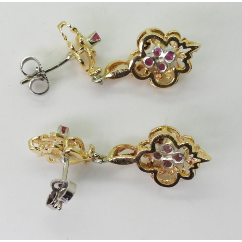 2763 - A PAIR OF CANADIAN RUBY EARRINGSthe pretty scroll mount is made in yellow and white metal and set wi... 