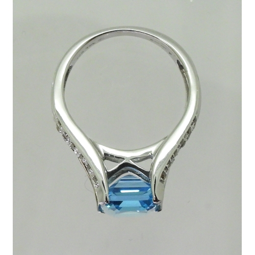 2766 - A BLUE TOPAZ & DIAMOND RINGmade by the jewellery channel in 14k white gold, the step cut blue to... 