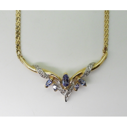 2772 - A TANZANITE AND DIAMOND NECKLACEmounted in 14k gold, largest tanzanite 7mm x 3.5mm, with grain set d... 