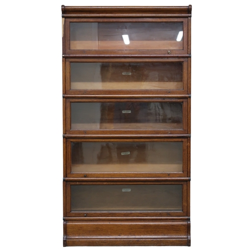 2032 - A 20TH CENTURY STAINED OAK GLOBE WERNICKE CO LTD SECTIONAL BOOKCASE with shaped top over five g... 