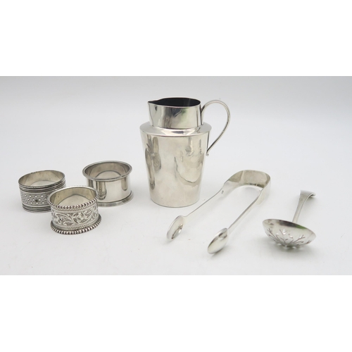 223 - A collection of silver including a silver cream jug, by Charles Edwards, London, silver napkin rings... 