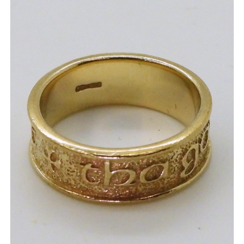 774 - A 9ct gold ring with embossed Celtic phrase 'Tha gaol agam ort' - I Love you, made by Ola Gorie, sta... 