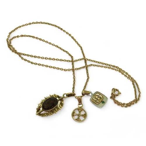 779 - A 9ct gold smoky quartz retro pendant, an Ola Gorie 9ct Celtic cross pendant, a 10k emerald pendant ... 