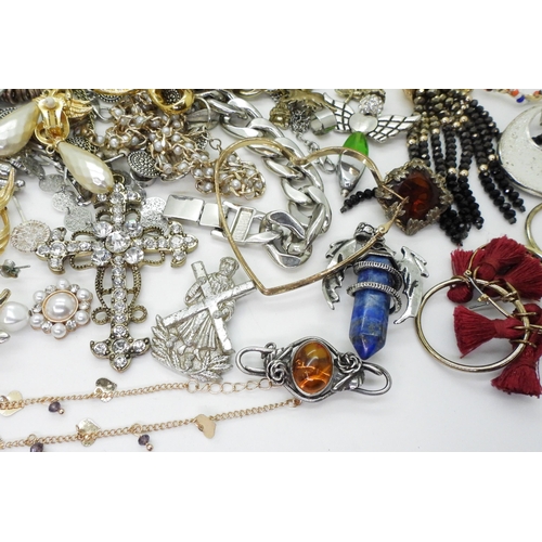 826 - a collection of silver and costume jewellery to include silver bangles, an amber brooch, a silver ri... 