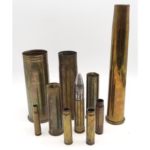 584 - An inert artillery round, together with a selection of brass shell casings, including a WW1 Trench A... 