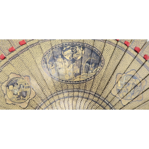 2380 - A CANTONESE EXPORT BLACK AND GOLD LACQUERED FAN Painted with panels of figures in gardens and landsc... 