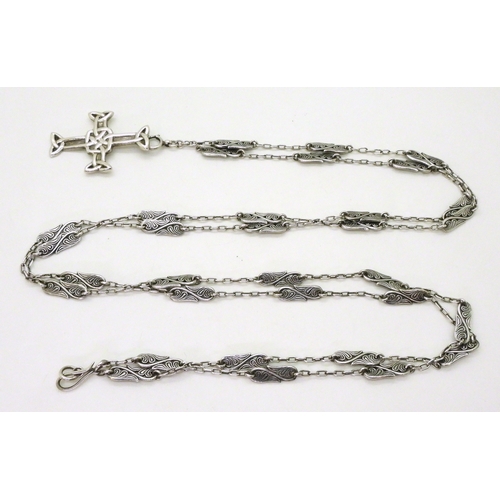 2777 - AN ALEXANDER RITCHIE JEWELthe white metal Celtic cross is suspended on a vine pattern long chain. th... 