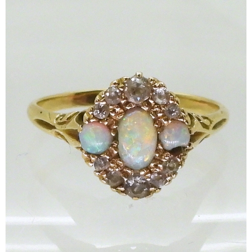 2778 - AN 18CT GOLD VINTAGE RINGset with three opals and old cut diamonds. With galleried mount and scroll ... 