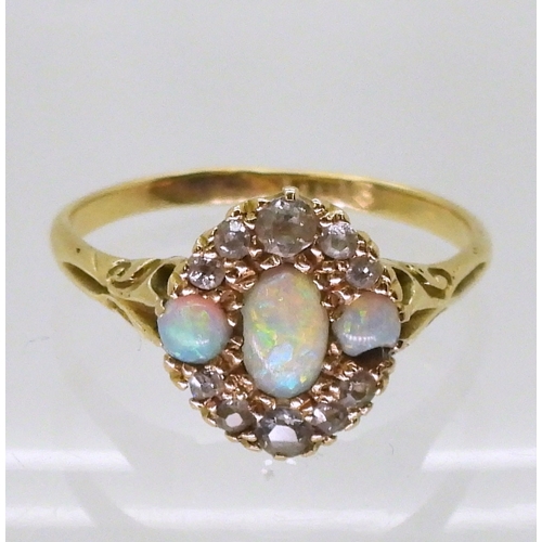 2778 - AN 18CT GOLD VINTAGE RINGset with three opals and old cut diamonds. With galleried mount and scroll ... 