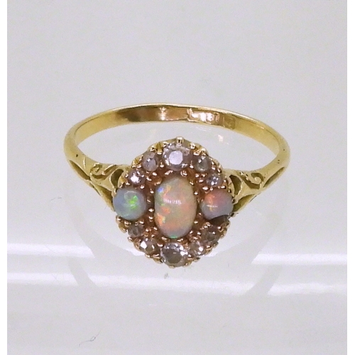 2778 - AN 18CT GOLD VINTAGE RINGset with three opals and old cut diamonds. With galleried mount and scroll ... 