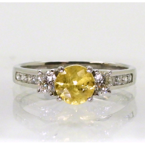 740 - A platinum, yellow sapphire and diamond ring, set with a 6mm round cut sapphire, and 0.50cts of bril... 