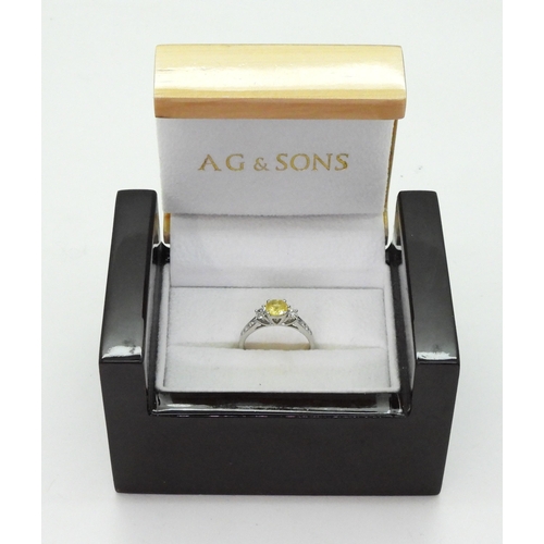 740 - A platinum, yellow sapphire and diamond ring, set with a 6mm round cut sapphire, and 0.50cts of bril... 