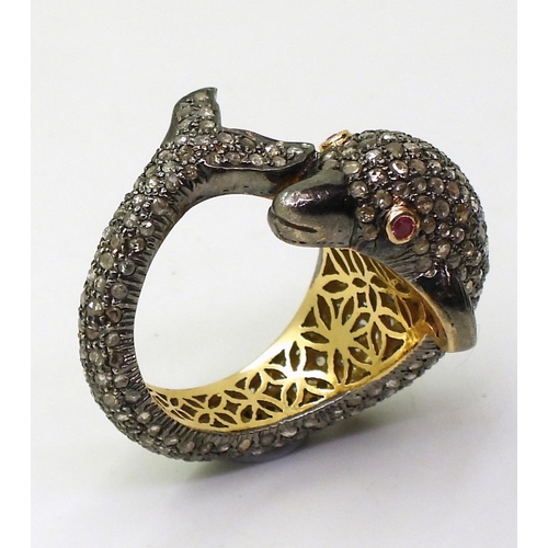 751 - A yellow and white metal dolphin ring completely pave set with rose cut diamonds, with ruby set eyes... 