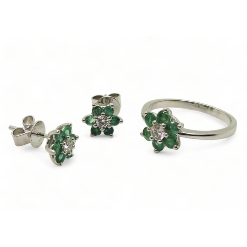 762 - A 14k white gold emerald and diamond flower ring, size O, with matching earrings, set with estimated... 