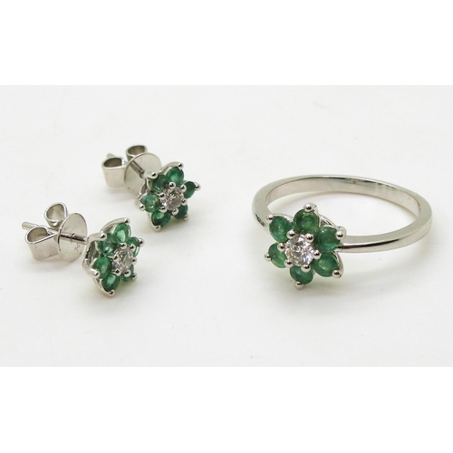 762 - A 14k white gold emerald and diamond flower ring, size O, with matching earrings, set with estimated... 