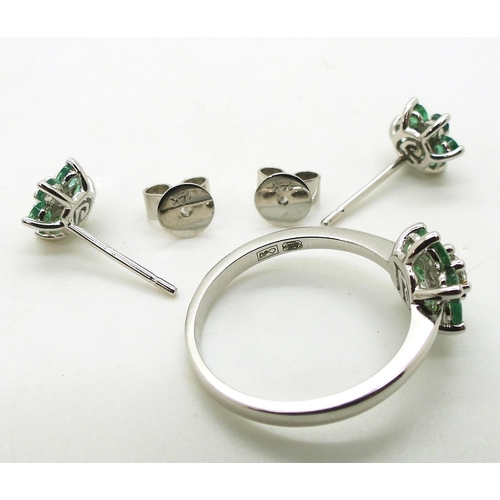 762 - A 14k white gold emerald and diamond flower ring, size O, with matching earrings, set with estimated... 