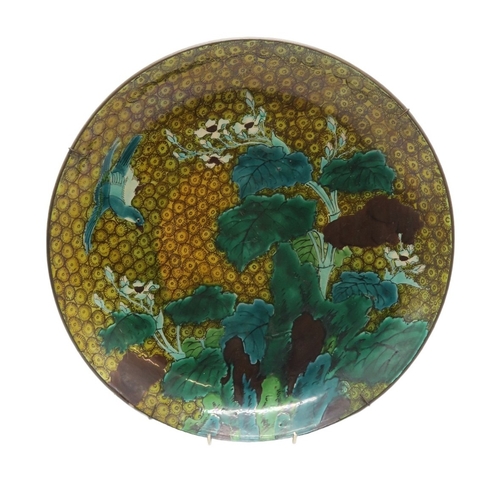 2392 - A JAPANESE CIRCULAR DISHPainted with a bird in flight above plantain on a cell pattern ground, 37cm ... 