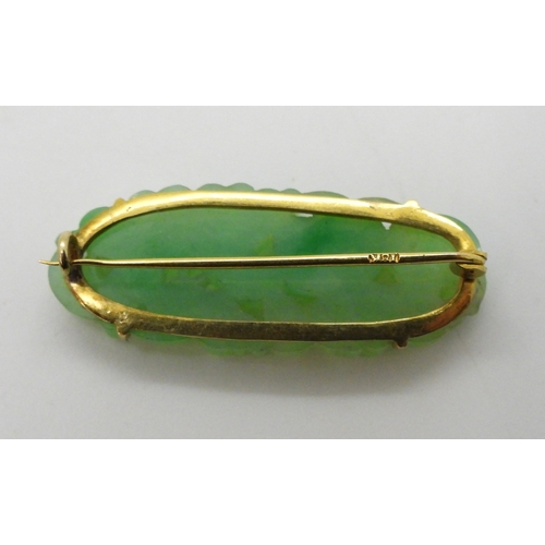 2784 - A CHINESE GREEN HARDSTONE BROOCHmounted in 18k gold, and carved with fruit and flowers. dimensions 3... 